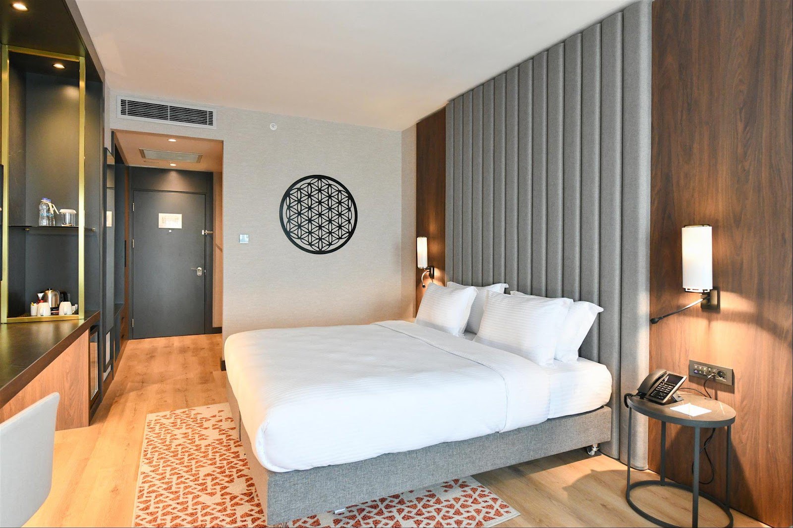 A stylish and contemporary guest room featuring a comfortable king-size bed, wooden flooring, and modern decor.