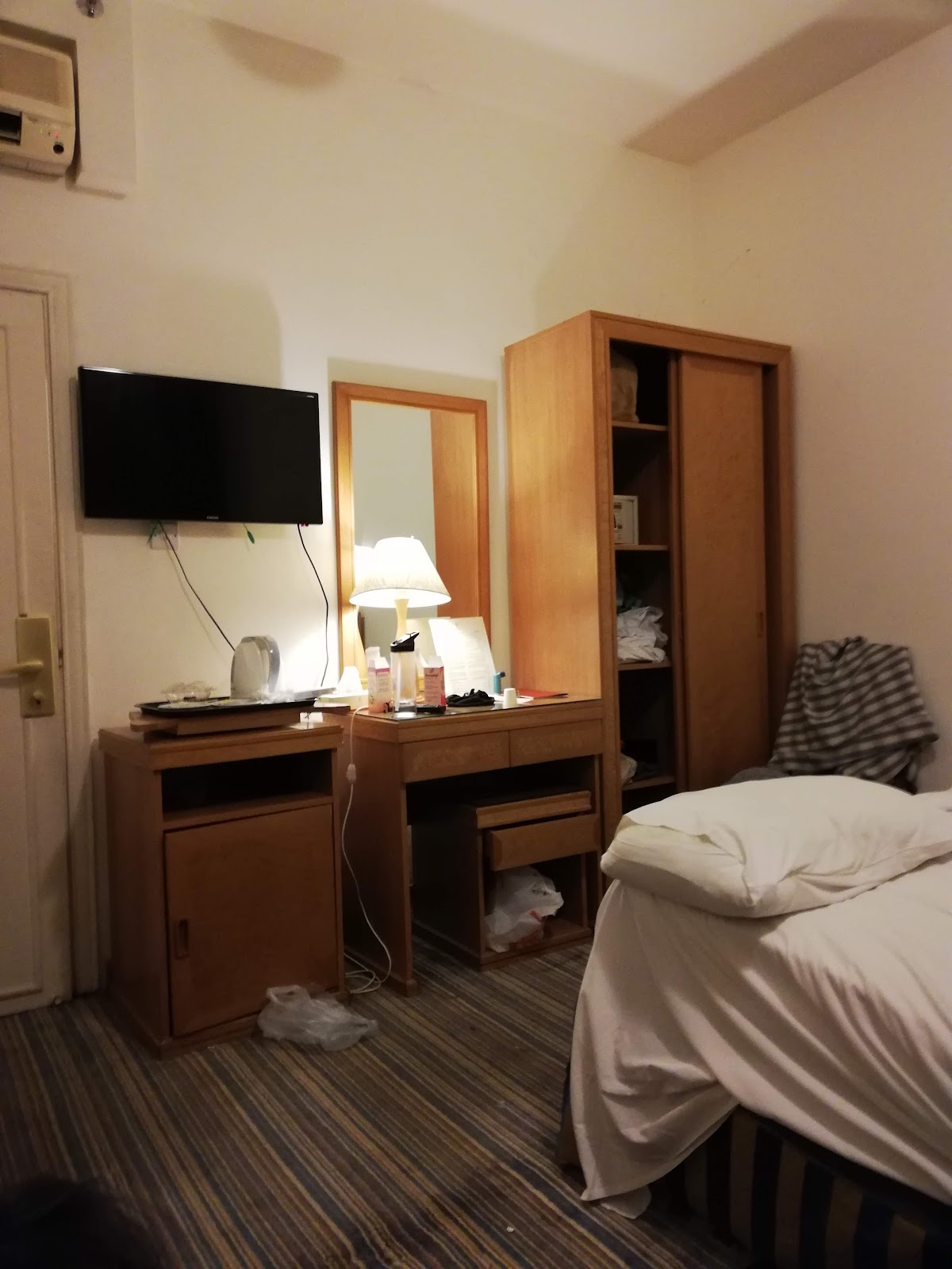 A cozy standard room featuring a single bed, a desk, and a television, equipped for a solo pilgrim or as an additional bed.