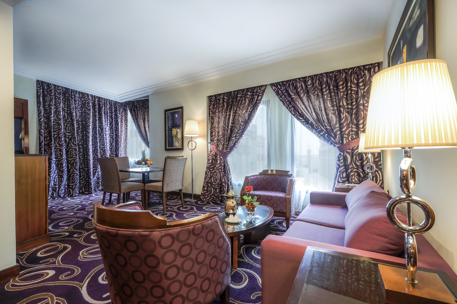 A luxurious and expansive suite living area, complete with a comfortable sofa, armchairs, and a dining table, offering ample personal space for families.