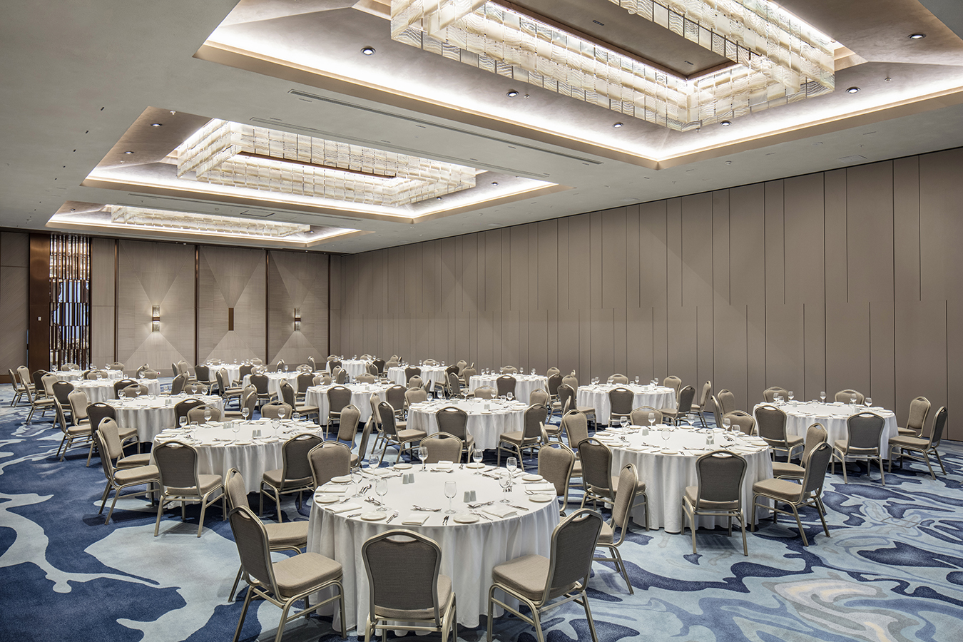 The hotel's sophisticated lobby lounge area, furnished with comfortable sofas and armchairs, a bar, and contemporary lighting.