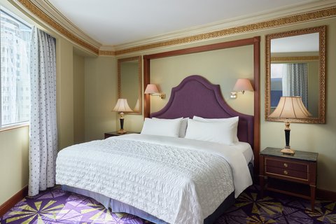 A luxurious and spacious hotel room featuring a comfortable king-size bed, elegant decor, and modern amenities, designed for ultimate guest comfort.