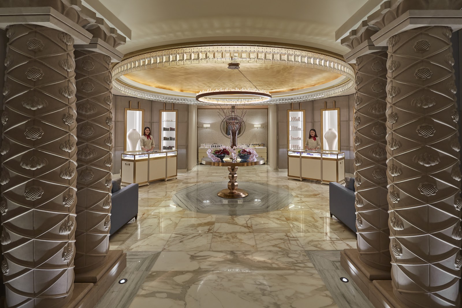 A lavish spa reception or boutique area with classical columns and product displays, with modestly dressed staff.