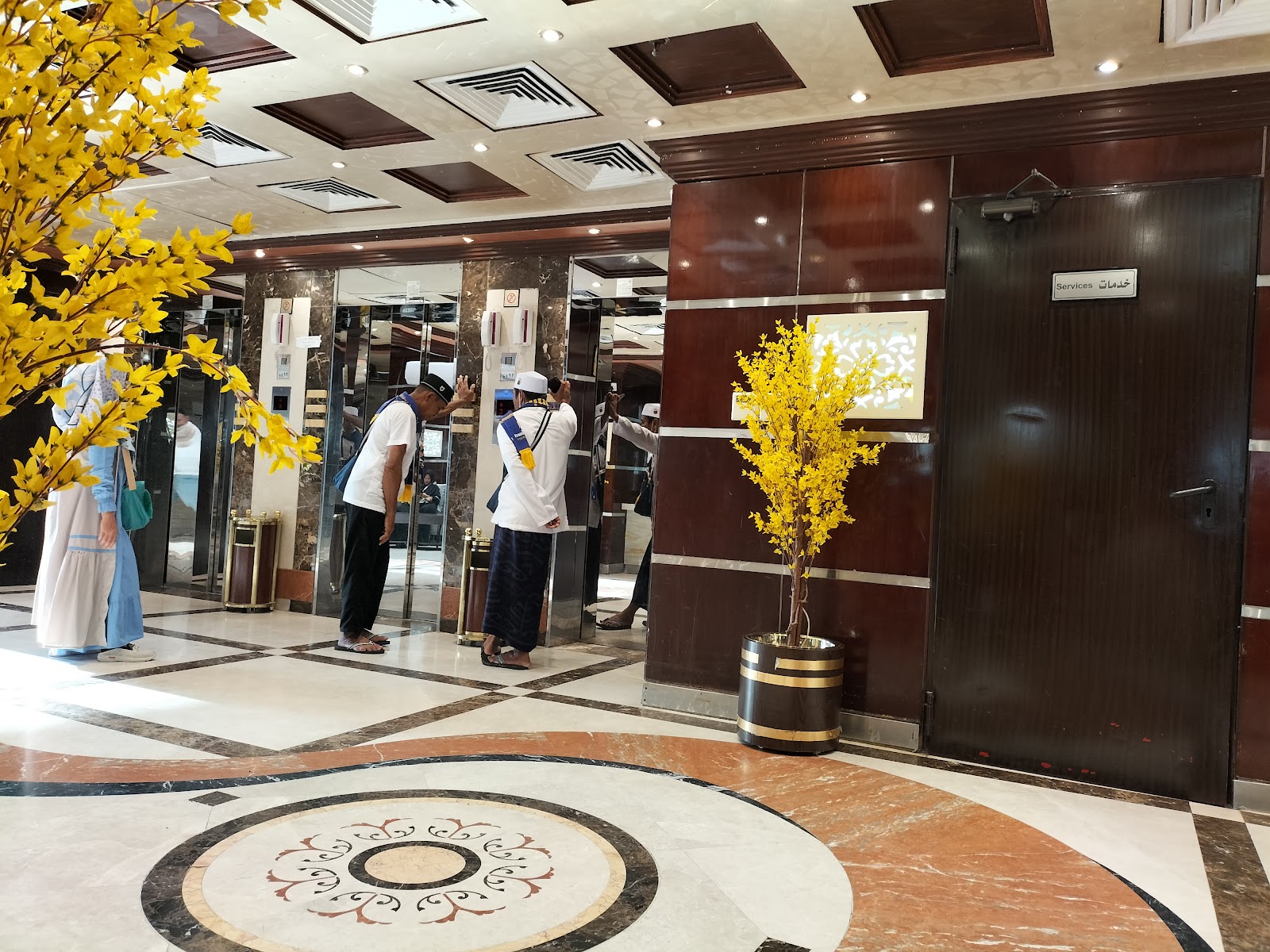 The hotel lobby or common area with elevators, featuring traditional patterns and decor, designed for guest circulation.